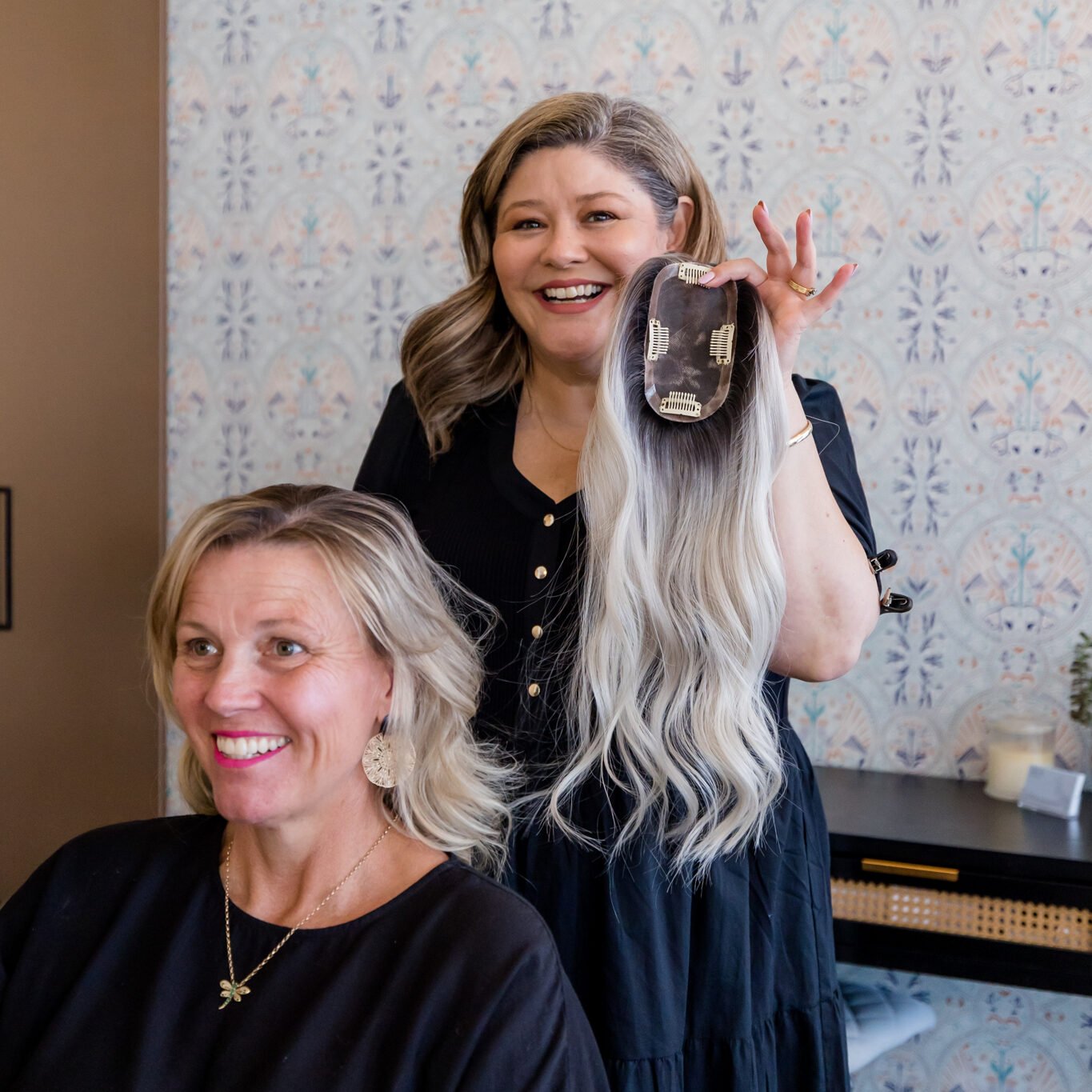 Madeleine Fisher holding a bespoke human hair topper beside a smiling client at Solo Tú in Orange NSW